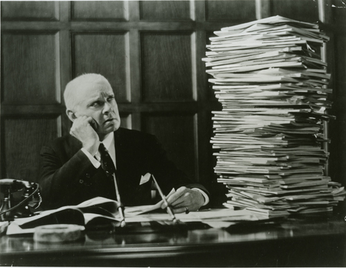 man looking at stack of papers